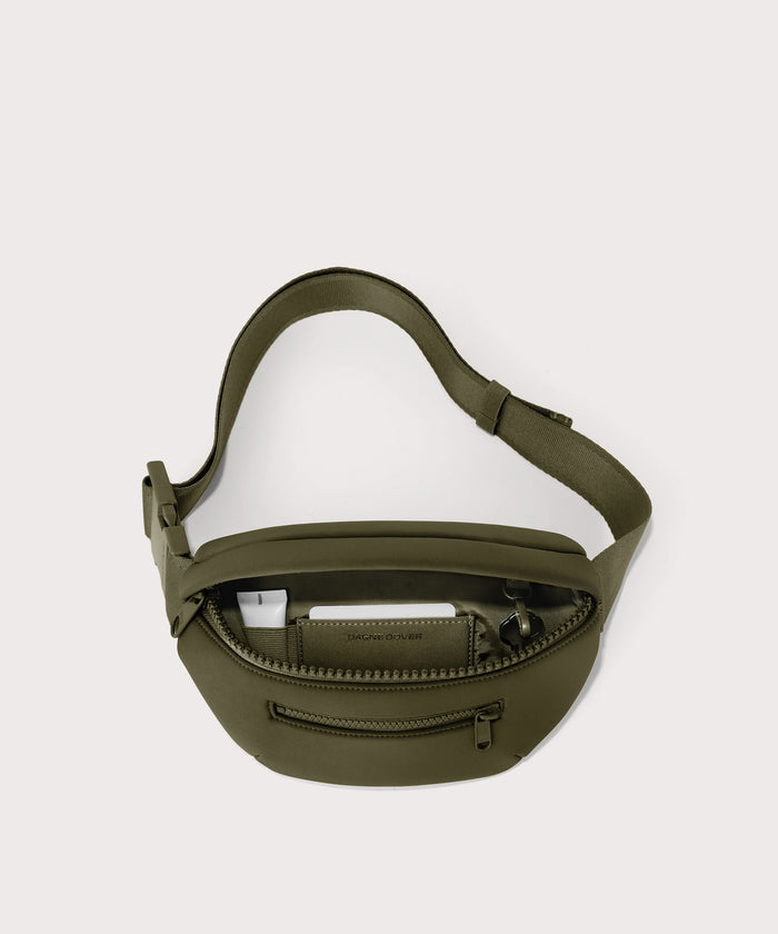 Dagne Dover Ace Fanny Pack in  dark green  unzipped, exposing the interior pockets
