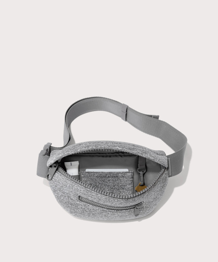 Dagne Dover Ace Fanny Pack in grey  unzipped, exposing the interior pockets