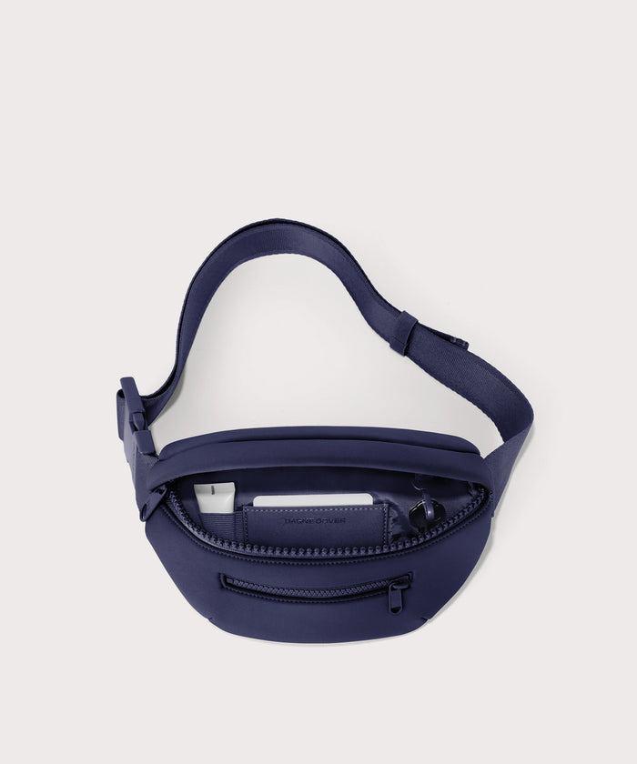 Dagne Dover Ace Fanny Pack in  dark blue  unzipped, exposing the interior pockets