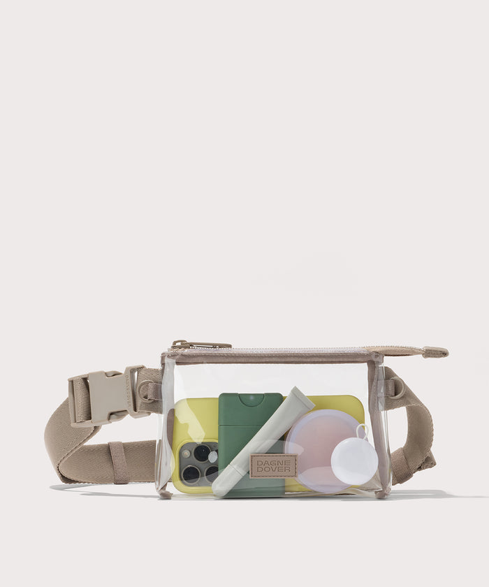 Clear crossbody bag with beige strap on a white background with phone and accessories  Stadium compliant.