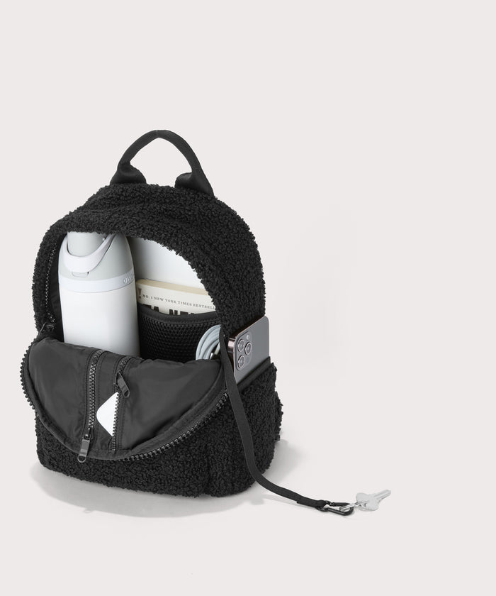 Dakota Small backpack pack in a black. unzipped, top down view.  In a  Faux Shearling  a soft, wool-like plush made with recycled materials