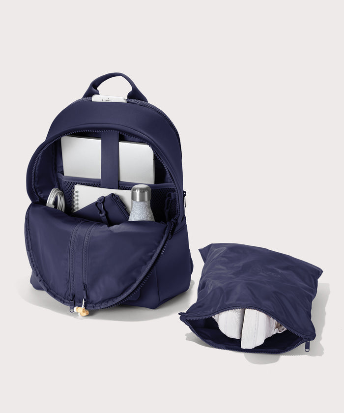 Dagne Dover large Dakota Neoprene Backpack in dark blue unzipped, showing the interior pockets and shoe bag.