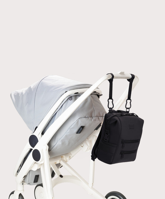 Dagne Dover small Indi Diaper Backpack in black attached to a stroller.