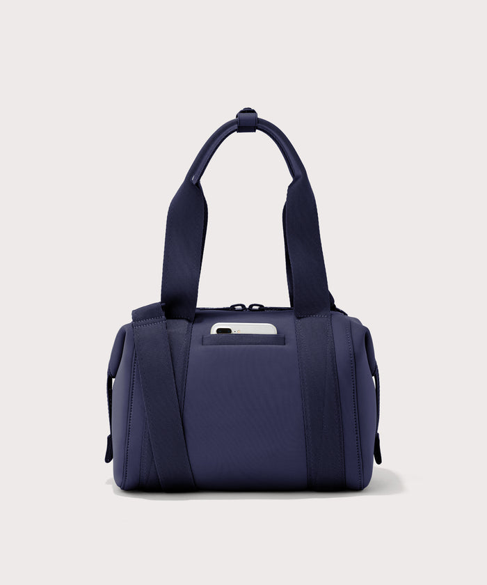 small Landon Carryall in dark blue, displaying an exterior phone pocket