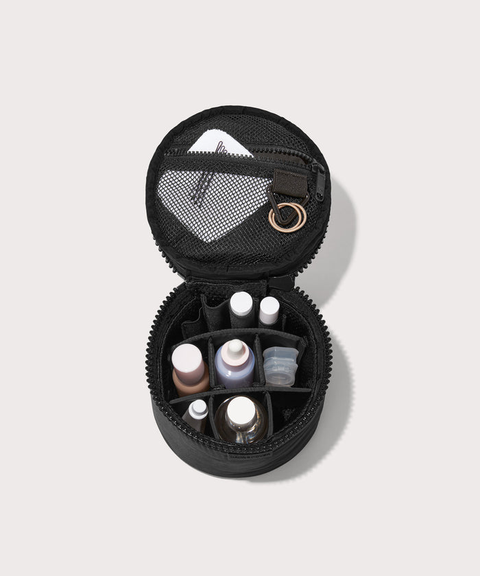 Dagne Dover small Mila Toiletry Pouch in black unzipped filled with toiletry products.