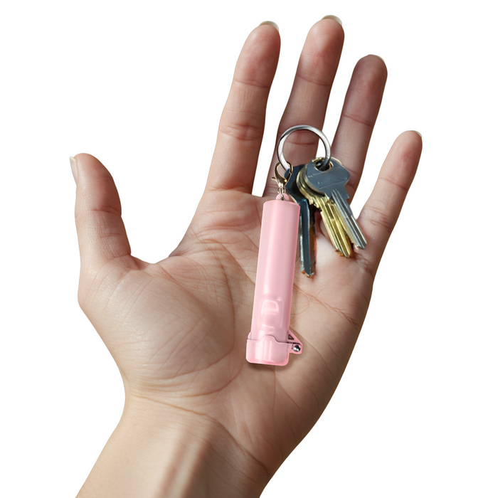 small pink pepper spray in hand on keychain
