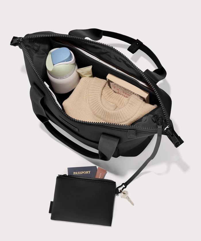 Tote  bag in a black seen from the top down view showing interior mesh pouch.