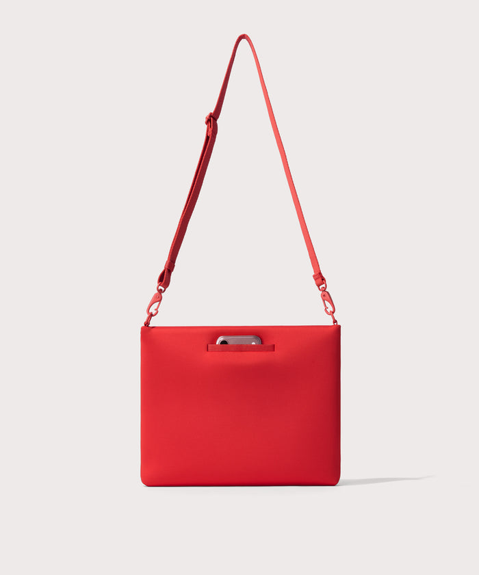 14 inch laptop shoulder bag in a  fiery, saturated red leaning toward orange seen from the back view showing phone pocket.