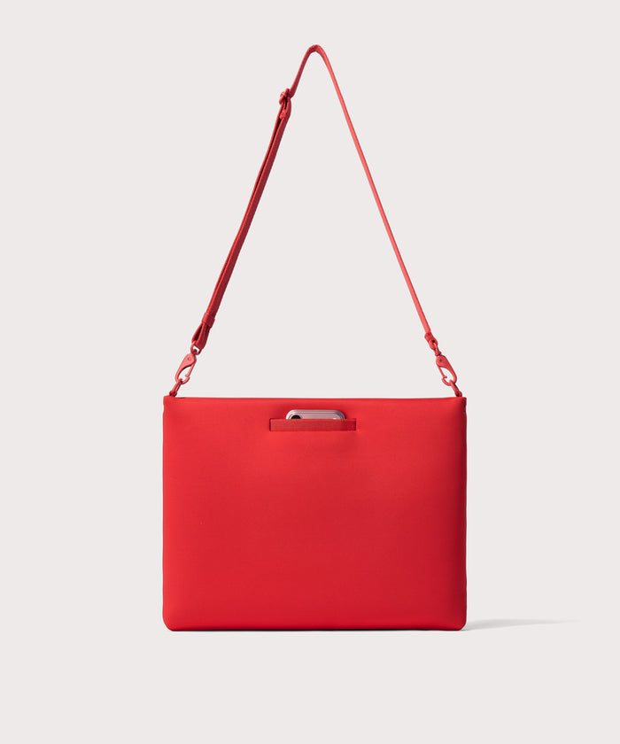 16 inch laptop shoulder bag in a  fiery, saturated red leaning toward orange seen from the back view showing phone pocket.
