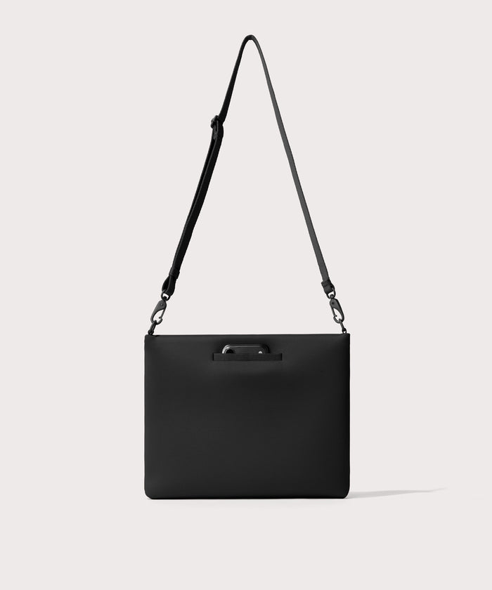 14 inch laptop shoulder bag in a  black seen from the back view showing phone pocket.’
