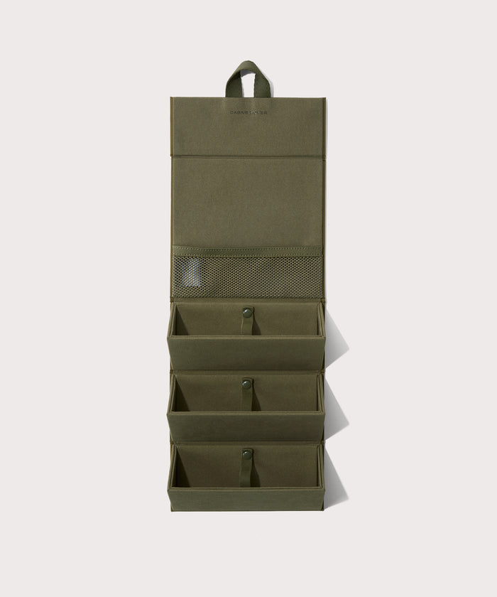 Dagne Dover Remi foldable glasses holder in dark green hung up.