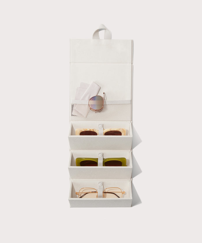 Dagne Dover Remi foldable glasses holder in white hung up and holding glasses.