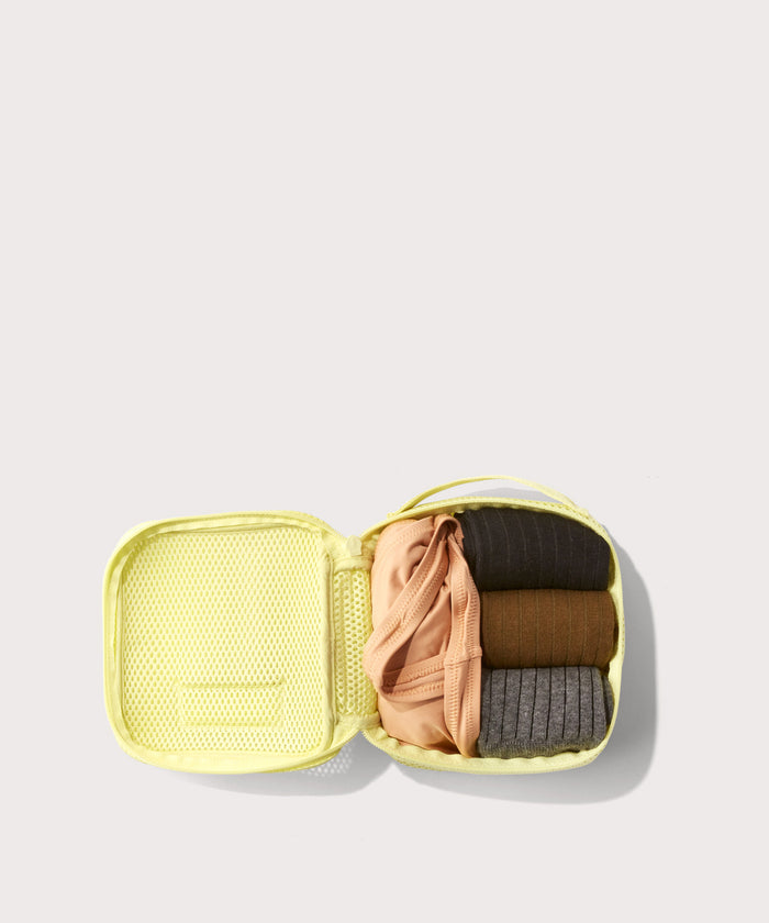 small Roma packing cube in citrine open with jeans inside