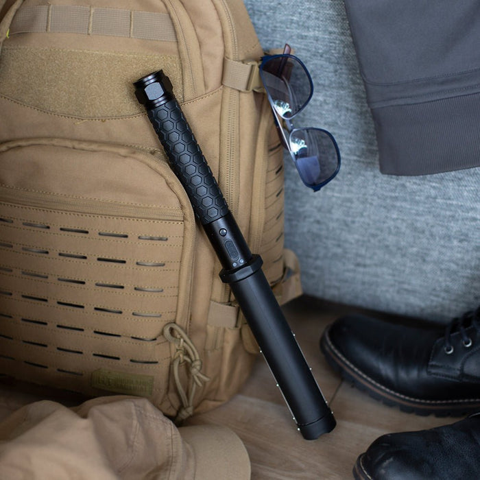 flashlight stun gun next to backpack