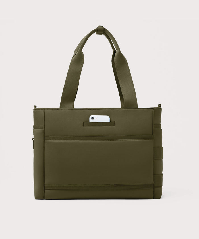 Dagne Dover large Wade Diaper Tote in dark green seen from the back with a phone in the exterior phone pocket.
