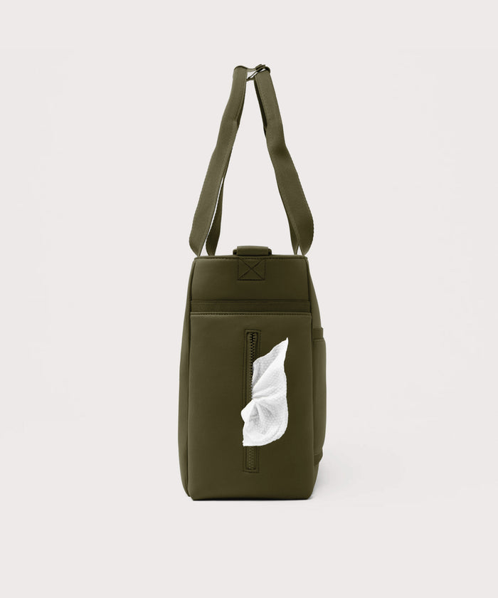 Dagne Dover large Wade Diaper Tote in dark green seen from the side, with a wet wipe poking out of the slip pocket.