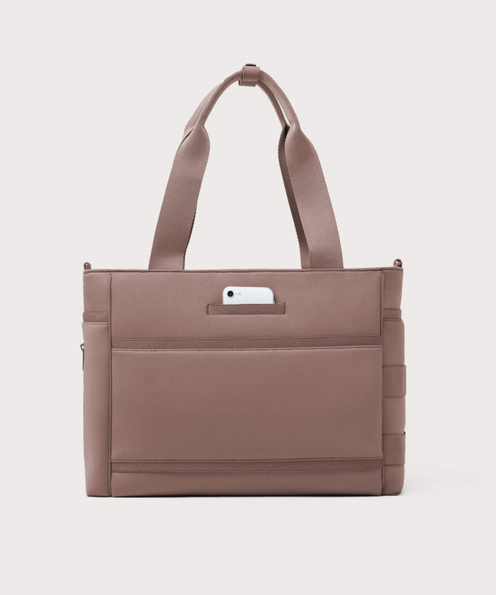 Dagne Dover large Wade Diaper Tote in pink seen from the back with a phone in the exterior phone pocket.