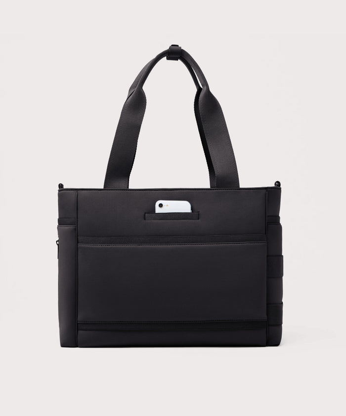 Dagne Dover large Wade Diaper Tote in black seen from the back with a phone in the exterior phone pocket.